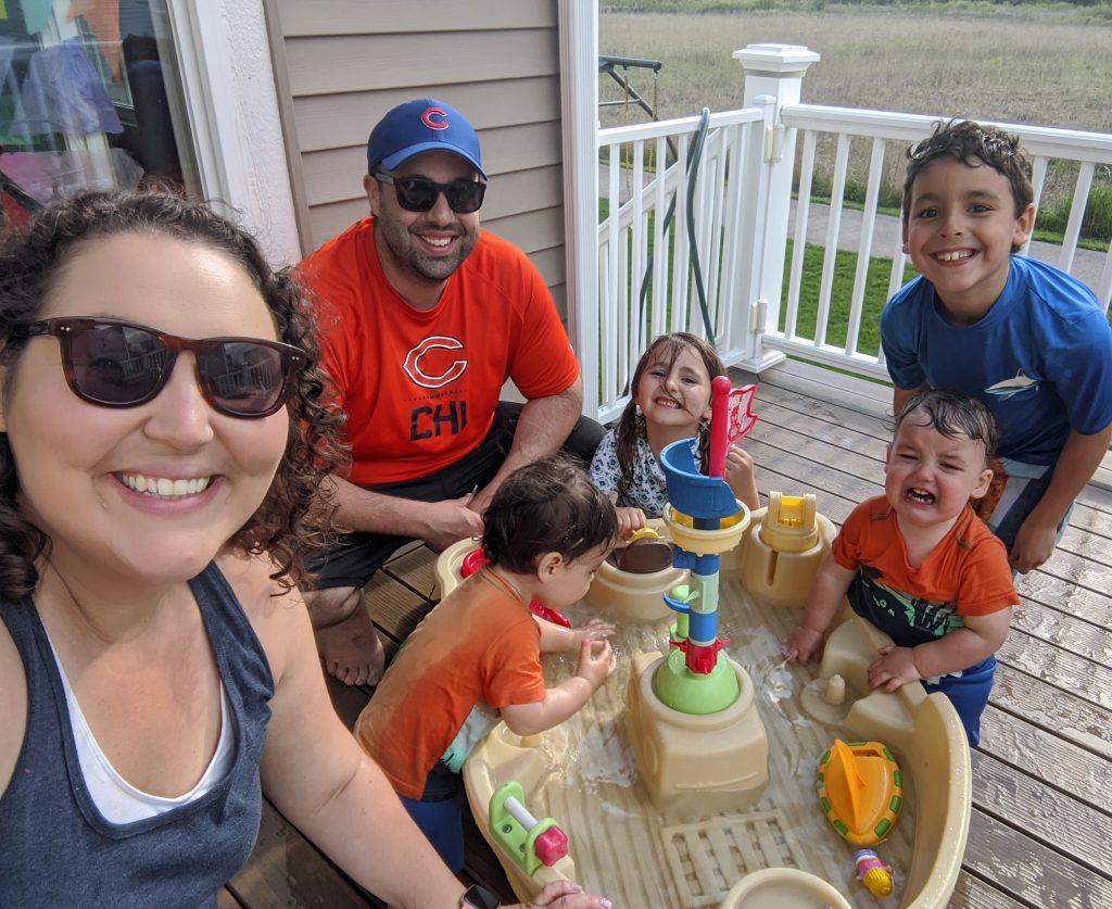 family of 6 sitting on a deck smiling at the camera